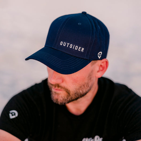 Navy Blue Cotton Twill hat with white embroidered Outsider logo offset on the front modeled on a man