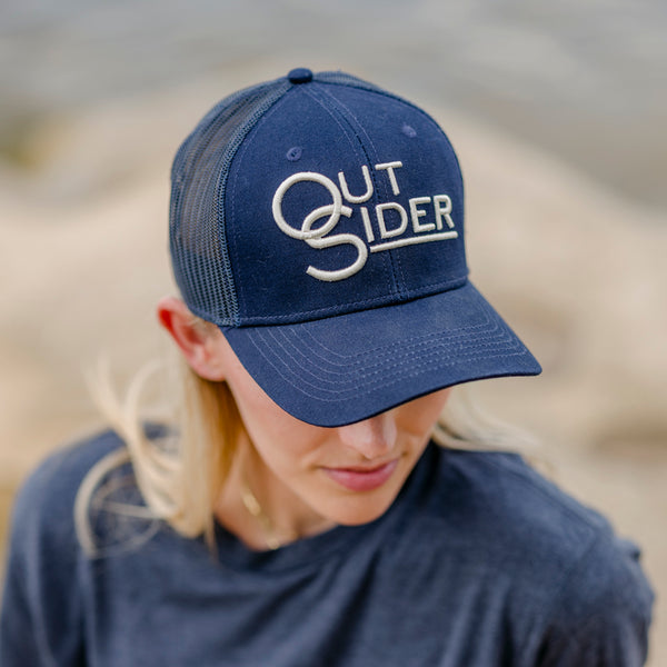 Navy Blue front panel and hat brim with White Outsider logo modeled on a woman